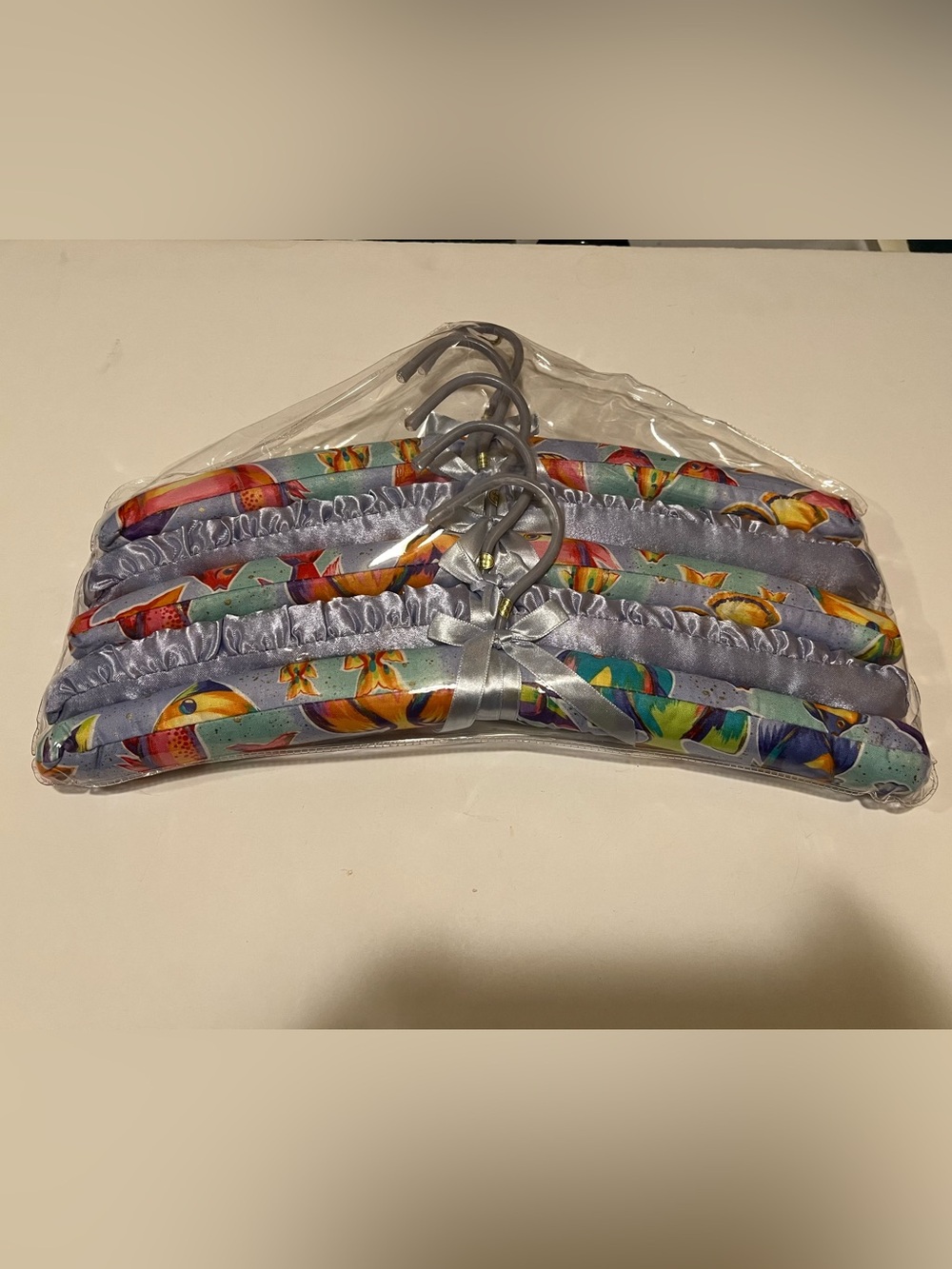 NWOT LOT OF COLORFUL PADDED FISH HANGERS.